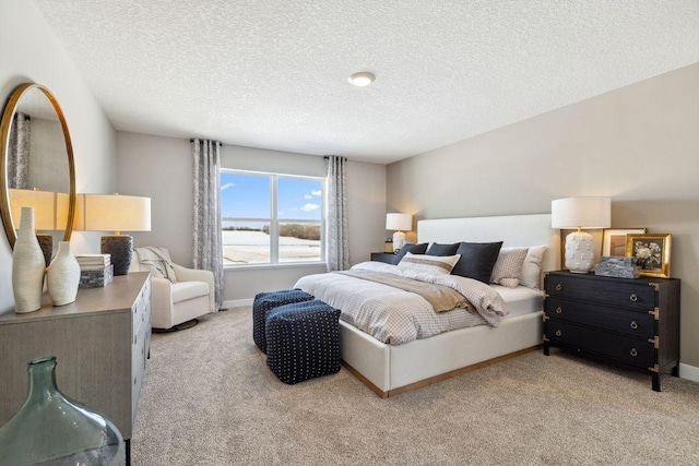 bedroom with a textured ceiling, light colored carpet, and baseboards