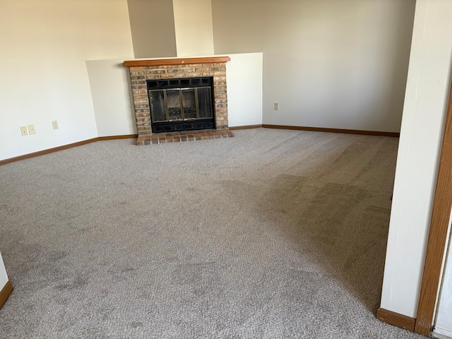 unfurnished living room featuring a fireplace, carpet floors, and baseboards