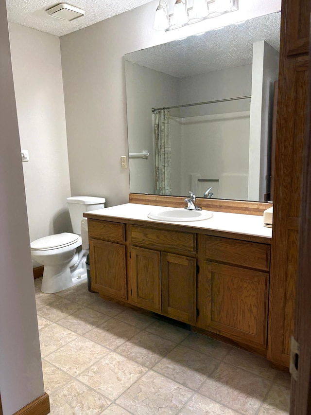 bathroom with curtained shower, a textured ceiling, toilet, and vanity