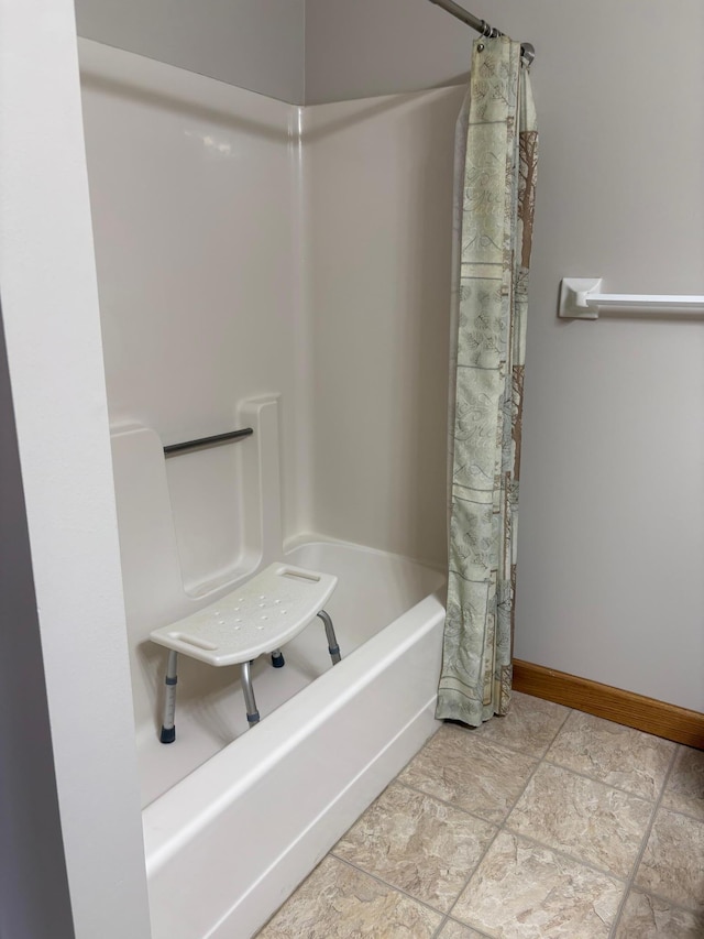 full bath featuring shower / bath combo with shower curtain and baseboards