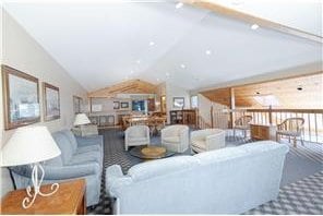 living area featuring vaulted ceiling and carpet