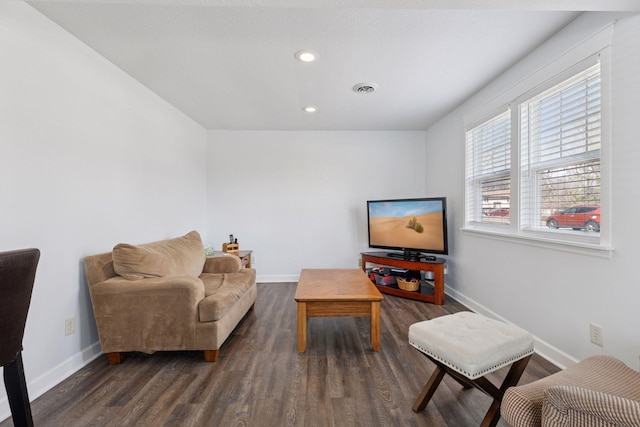 living room featuring dark wood-type flooring, visible vents, and baseboards