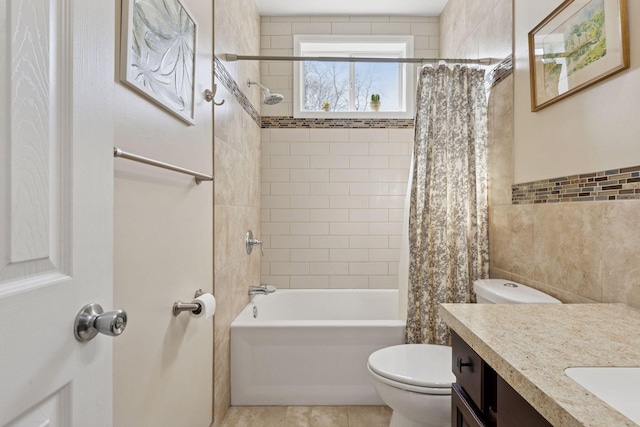 bathroom with tile walls, toilet, shower / tub combo with curtain, vanity, and tile patterned floors
