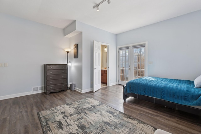 bedroom featuring visible vents, baseboards, track lighting, wood finished floors, and french doors
