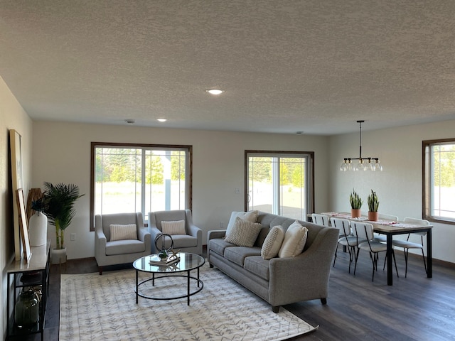 living room featuring an inviting chandelier, wood finished floors, and a textured ceiling