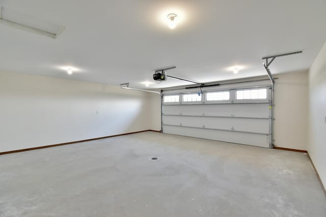 garage with baseboards and a garage door opener