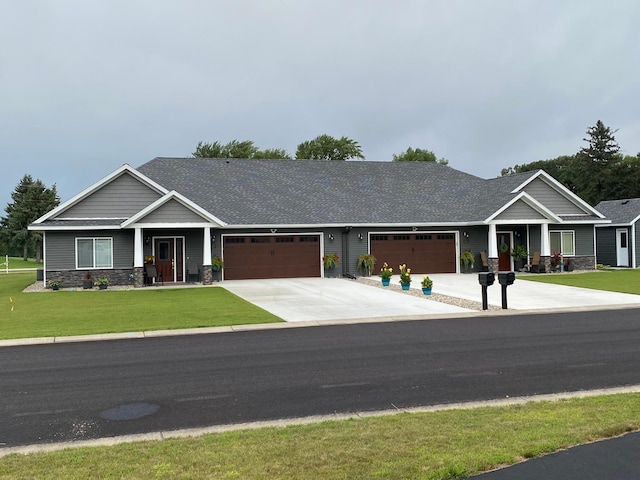 craftsman-style home featuring a garage, roof with shingles, stone siding, a front lawn, and driveway