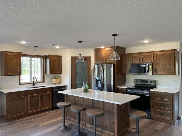 kitchen featuring a textured ceiling, dark wood-style flooring, a sink, and black appliances