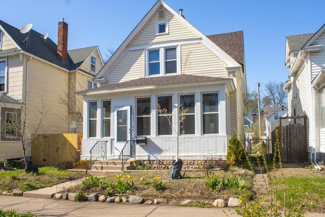 bungalow featuring fence and a shingled roof