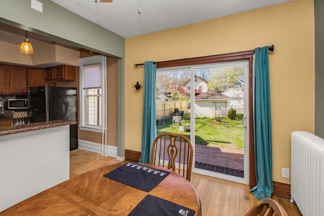 dining space featuring radiator, baseboards, and ceiling fan