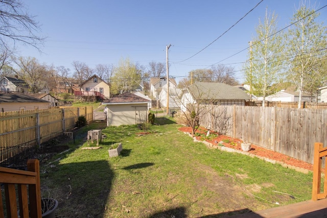 view of yard with a residential view, an outdoor structure, and a fenced backyard
