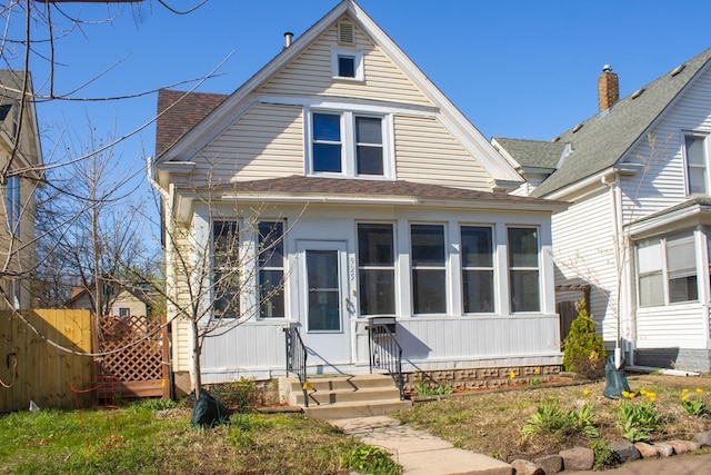 bungalow featuring fence, a shingled roof, and entry steps