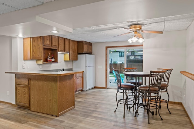 7165 Upper 157th St W, Apple Valley, MN 55124 - kitchen featuring freestanding refrigerator, a drop ceiling, baseboards, brown cabinetry, and light wood-style flooring