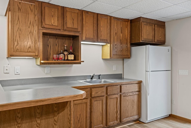 7165 Upper 157th St W, Apple Valley, MN 55124 - kitchen featuring a sink, freestanding refrigerator, brown cabinetry, and light wood-type flooring