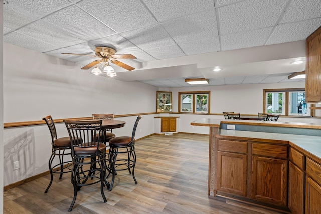 7165 Upper 157th St W, Apple Valley, MN 55124 - kitchen featuring light wood-style flooring, baseboards, a paneled ceiling, ceiling fan, and brown cabinets