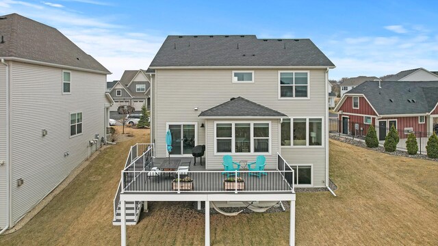 2301 Kester Ave NE, Saint Michael, MN 55376 - back of property featuring a deck, outdoor dining area, a shingled roof, a lawn, and a residential view