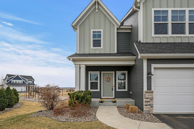 2301 Kester Ave NE, Saint Michael, MN 55376 - view of front of home featuring an attached garage, a shingled roof, board and batten siding, a playground, and covered porch