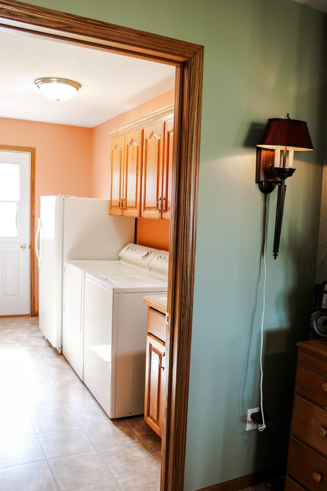 46377 Sunset Ct, Morris, MN 56267 - clothes washing area featuring cabinet space, washing machine and clothes dryer, and light tile patterned flooring