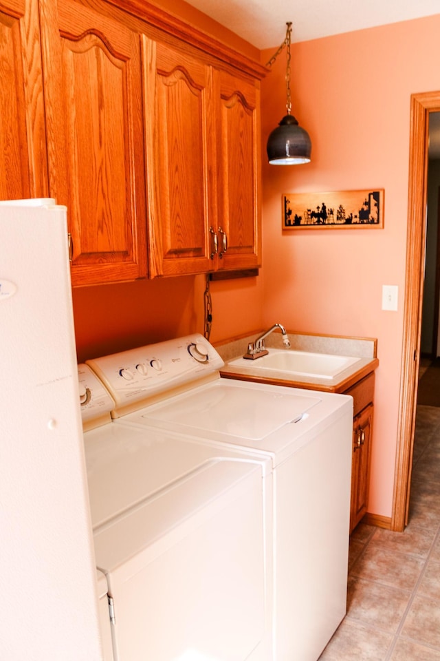46377 Sunset Ct, Morris, MN 56267 - laundry area with light tile patterned flooring, washer and clothes dryer, a sink, and cabinet space
