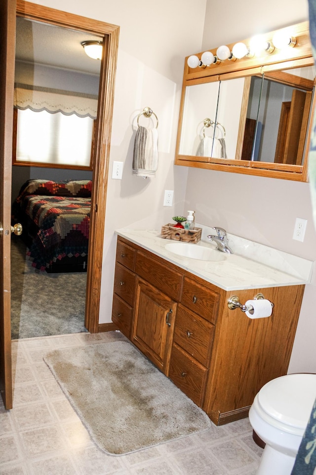 46377 Sunset Ct, Morris, MN 56267 - bathroom featuring toilet, tile patterned floors, vanity, and connected bathroom