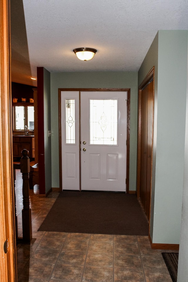 46377 Sunset Ct, Morris, MN 56267 - foyer entrance featuring a textured ceiling, baseboards, and plenty of natural light