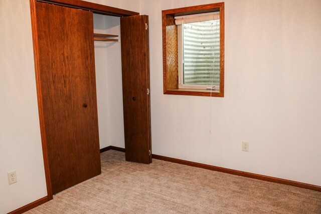 46377 Sunset Ct, Morris, MN 56267 - unfurnished bedroom featuring a closet, light colored carpet, and baseboards