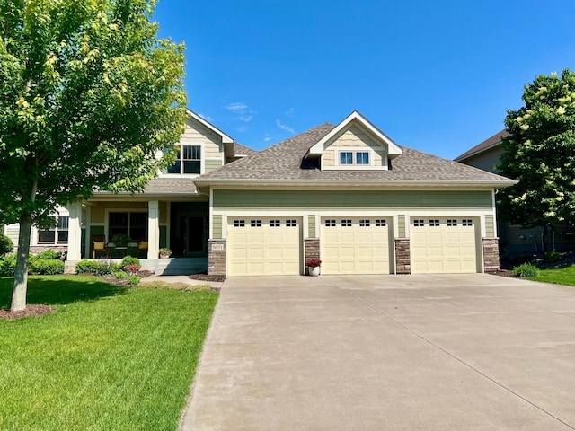 8871 Kahl Way NE, Otsego, MN 55362 - view of front facade with a garage, driveway, a front lawn, roof with shingles, and stone siding