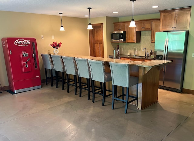 8871 Kahl Way NE, Otsego, MN 55362 - kitchen with stainless steel appliances, a kitchen bar, decorative backsplash, concrete floors, and recessed lighting