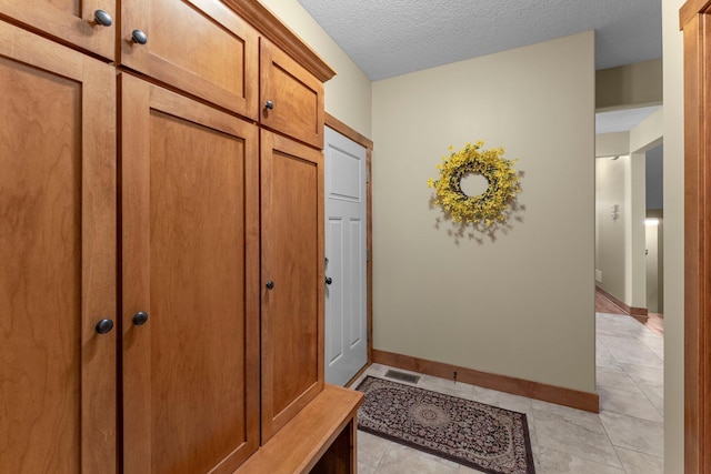 8871 Kahl Way NE, Otsego, MN 55362 - mudroom featuring light tile patterned flooring and a textured ceiling