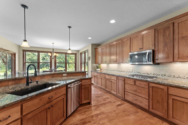 8871 Kahl Way NE, Otsego, MN 55362 - kitchen with appliances with stainless steel finishes, backsplash, light wood-style floors, decorative light fixtures, and recessed lighting