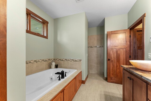 8871 Kahl Way NE, Otsego, MN 55362 - full bath featuring a whirlpool tub, vanity, and a textured ceiling