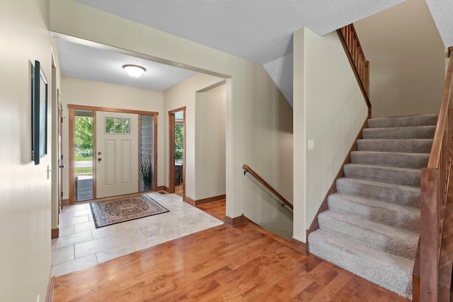 8871 Kahl Way NE, Otsego, MN 55362 - foyer entrance featuring wood finished floors, stairway, and a textured ceiling