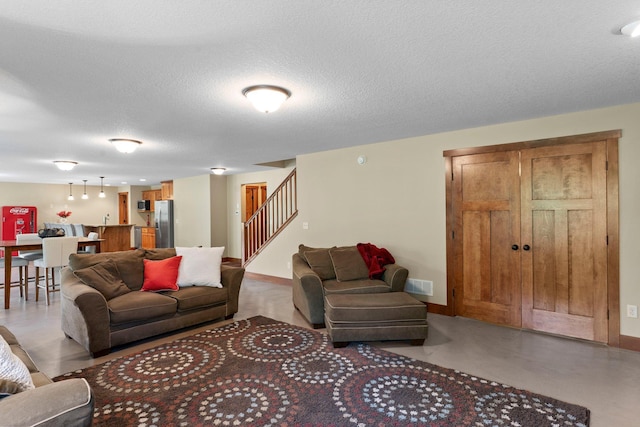 8871 Kahl Way NE, Otsego, MN 55362 - living area featuring stairs, a textured ceiling, and concrete flooring