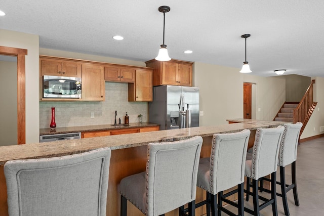 8871 Kahl Way NE, Otsego, MN 55362 - kitchen featuring stainless steel appliances, tasteful backsplash, a kitchen breakfast bar, recessed lighting, and hanging light fixtures