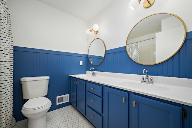 full bathroom featuring visible vents, a sink, and a wainscoted wall