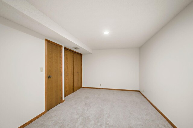 unfurnished bedroom featuring baseboards, light carpet, recessed lighting, and visible vents