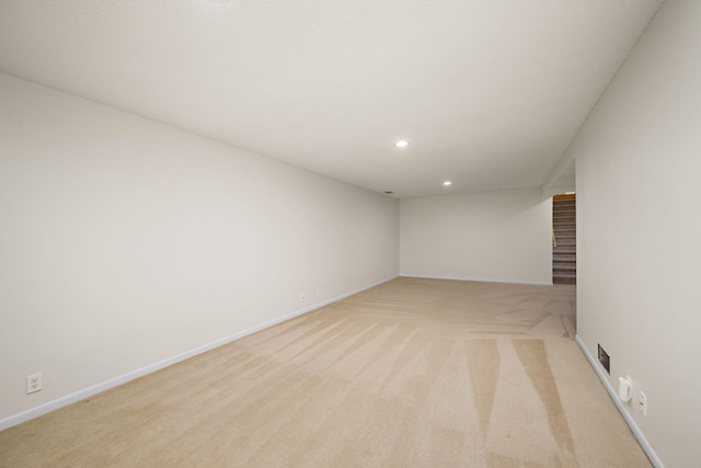 unfurnished room with recessed lighting, baseboards, and light colored carpet