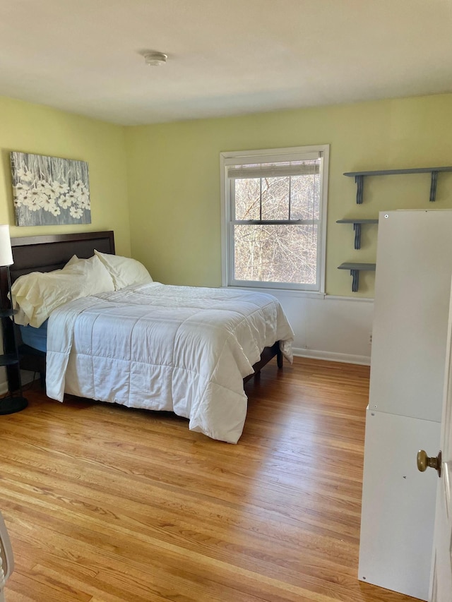 bedroom with light wood-style floors and baseboards