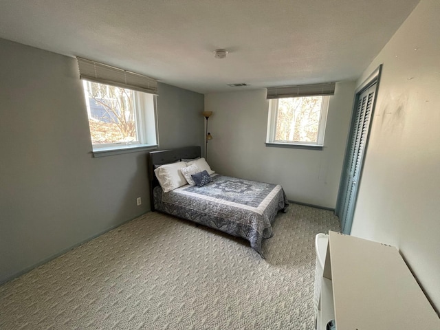 bedroom featuring visible vents, carpet flooring, and a closet