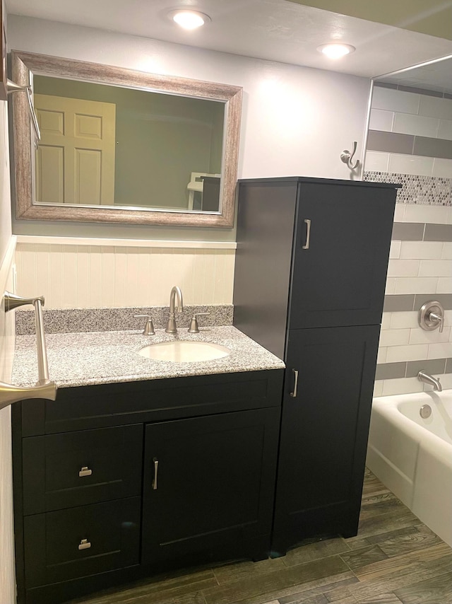 full bath with wood finished floors, vanity, shower / bathing tub combination, and recessed lighting