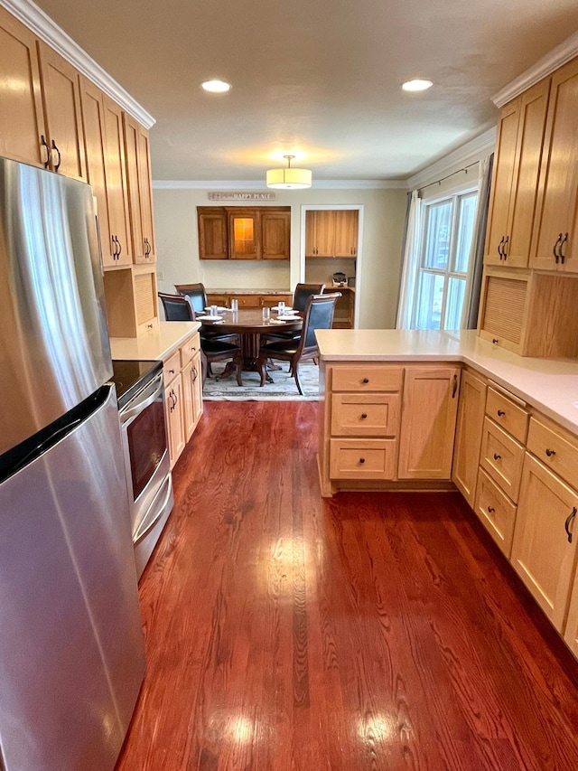 kitchen featuring light countertops, appliances with stainless steel finishes, a peninsula, dark wood finished floors, and crown molding