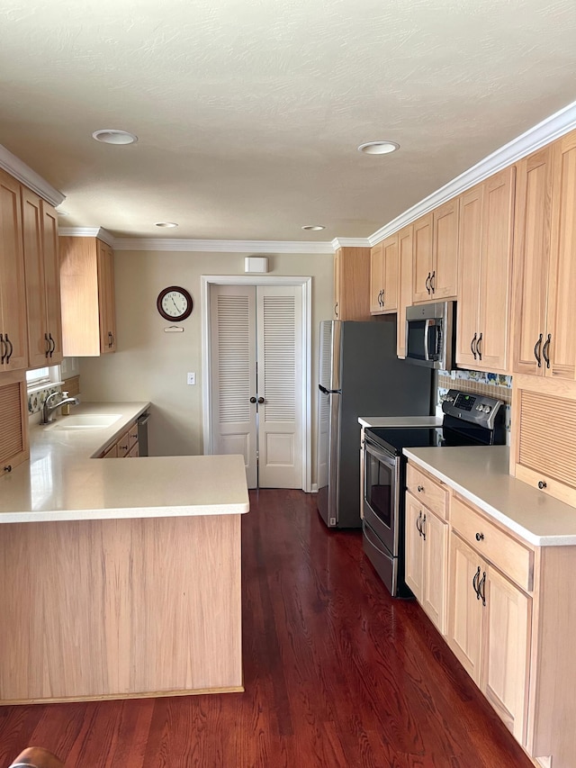 kitchen featuring light brown cabinets, a sink, ornamental molding, light countertops, and stainless steel appliances