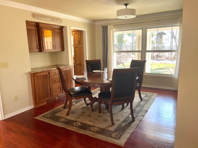 dining area with dark wood-style floors, baseboards, and ornamental molding