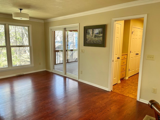 unfurnished room with crown molding, visible vents, baseboards, and dark wood-style floors