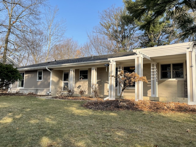 view of front of property with a porch, a shingled roof, and a front yard