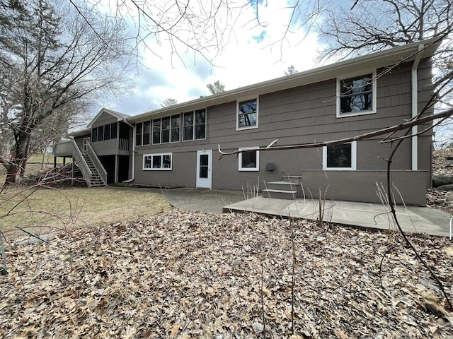 rear view of house featuring a patio area, a sunroom, and stairs