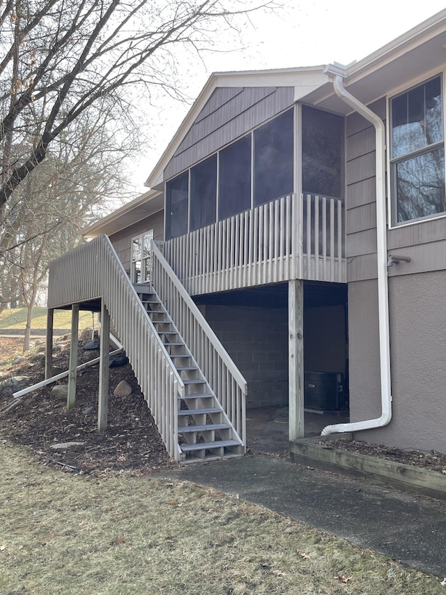 view of side of home featuring a sunroom and stairway