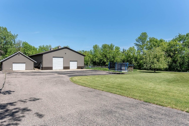 190 Stony Creek Rd, Mankato, MN 56001 - exterior space with a trampoline, a detached garage, an outdoor structure, a front lawn, and view of scattered trees