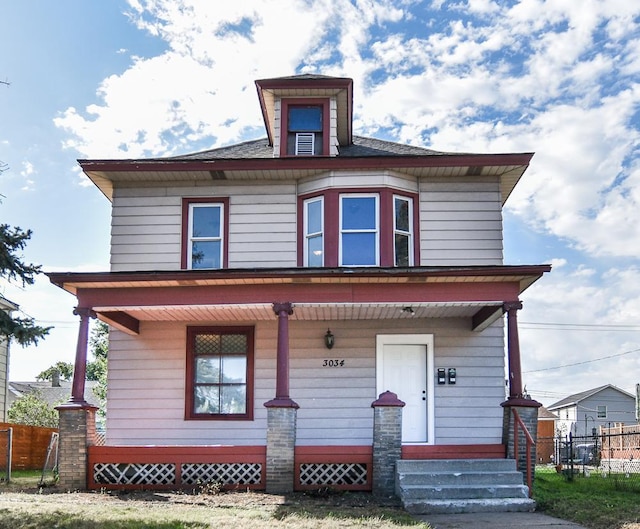 american foursquare style home featuring entry steps and fence