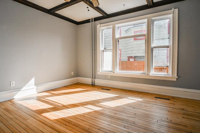 unfurnished room featuring hardwood / wood-style flooring, baseboards, and visible vents